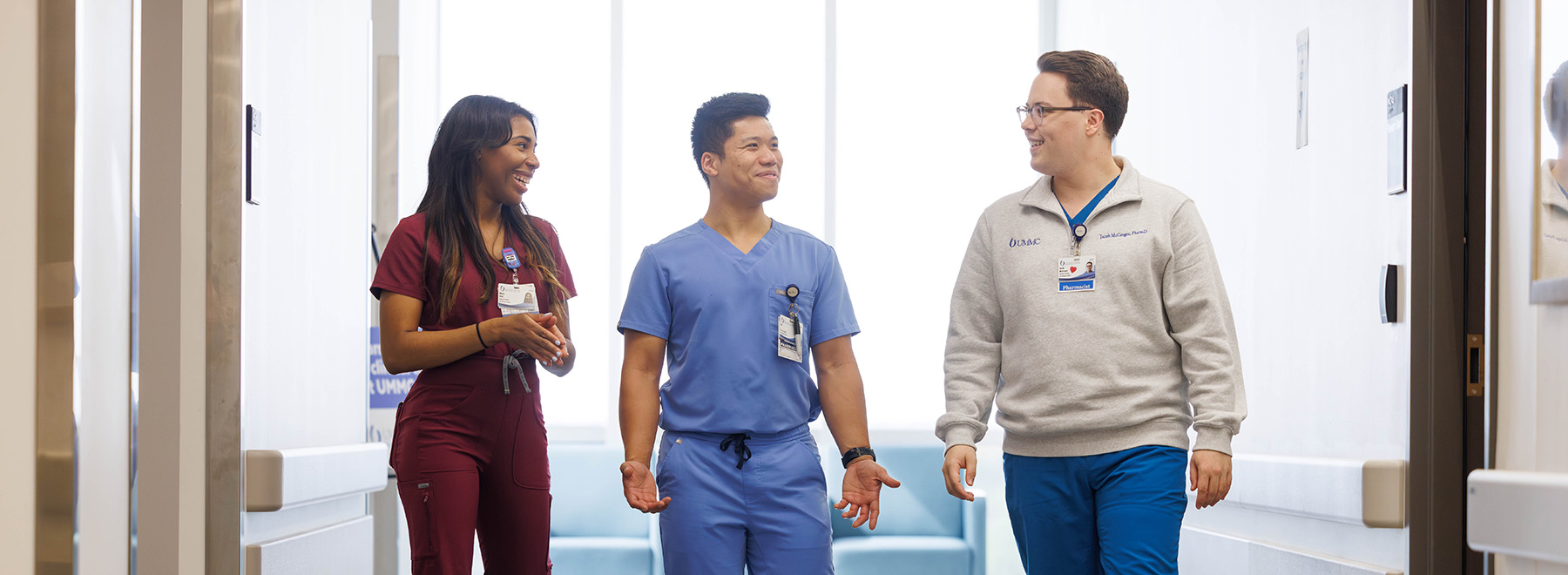 Three UMMC-based pharmacy residents interact as they walk down a patient hallway.