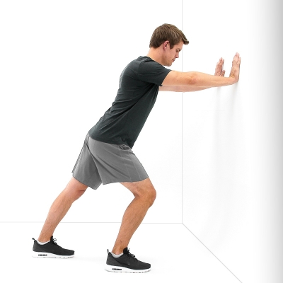 Man performing a standing calf stretch exercise.