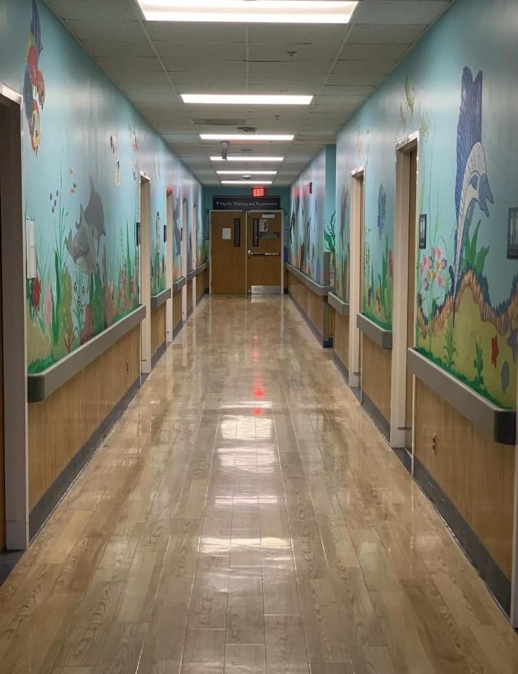 A hallway inside the clinic is painted on both sides with a mural depicting a cheerful ocean scene.