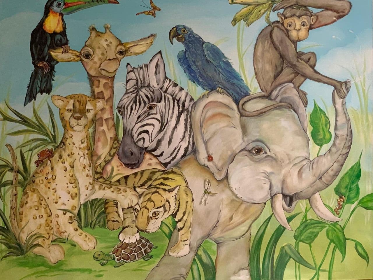 Colorful wall art in the clinic features an elephant, monkey, giraffe, cheetah, zebra, tiger, turtle, butterfly, and tucan.