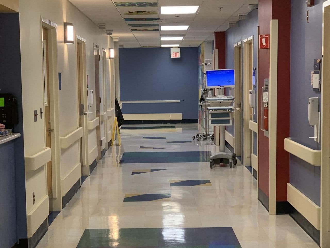 A hallway on the inpatient unit with bright colors and a computer stand in the hall.