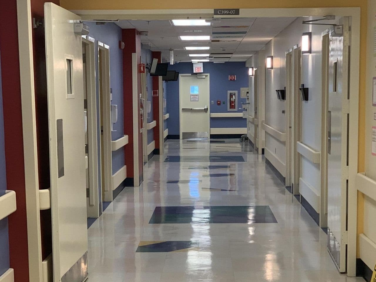A hallway on the unit has walls painted in red, blue, and yellow.