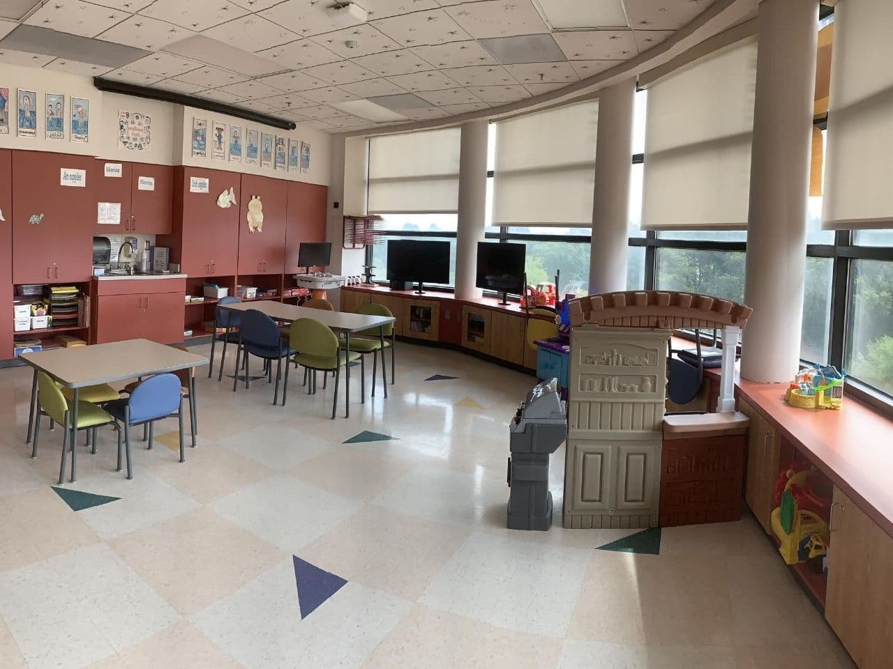 The inpatient playroom has a number of kid-sized tables and chairs with lots of floor space.