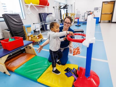 A physical therapist works with a child.