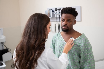 A learner examines a male standardized patient.