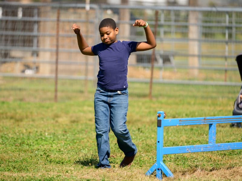 A boy lifts his arms in joy at Family Fun Day 2026.