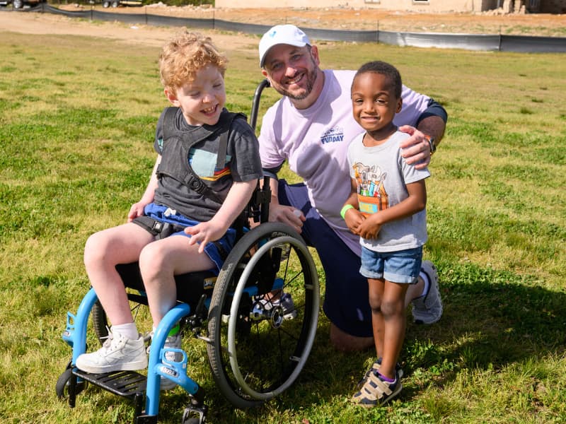Dr. Ian Hoppe smiles as he visits with two children at Family Fun Day 2026.