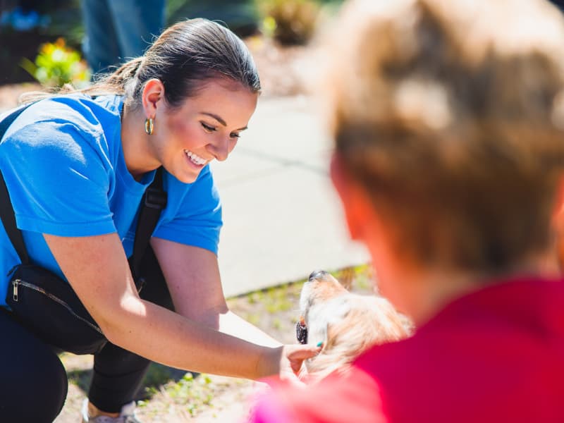 A woman pets a dog during Family Fun Day.