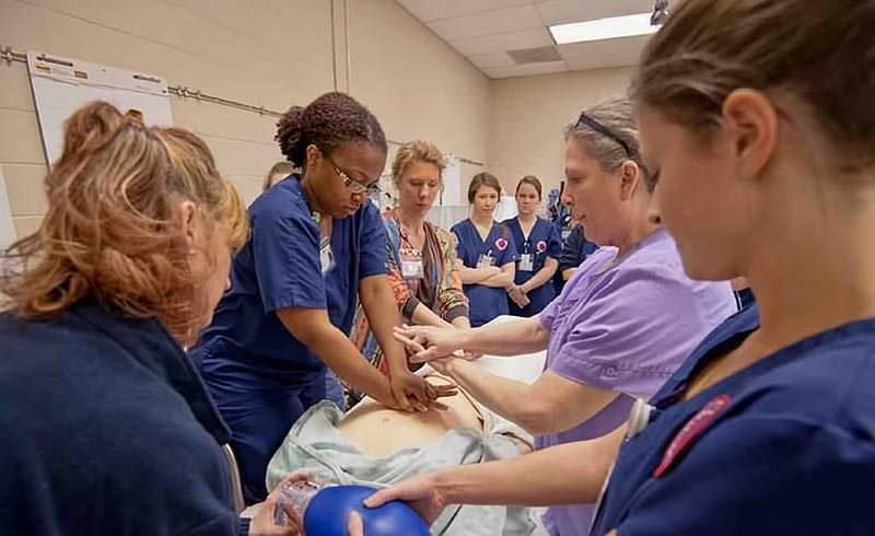 Nursing students practicing on resuscitation dummy