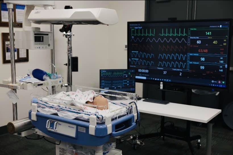 Neonatal simulation room with mannequin of a premature baby in an incubator.