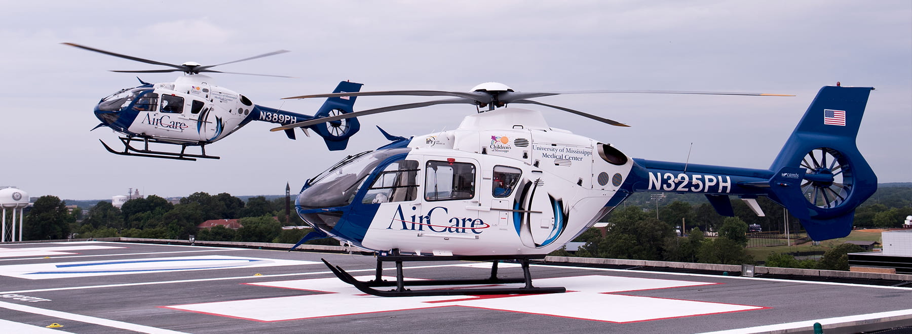 Two AirCare helicopters with one in flight