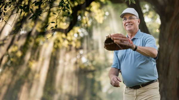 Featured patient waits to catch baseball while holding out glove.