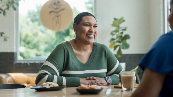 A patient smiles while sitting at a table during an interview.