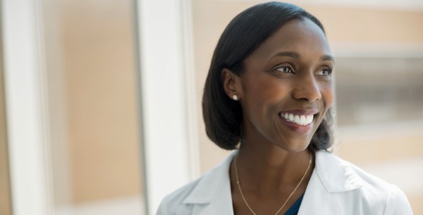 Doctor smiles while looking out window.