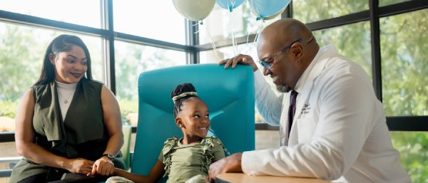 Girl smiles while looking at her Doctor.