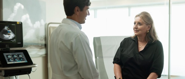 Patient talks to Doctor in exam room.