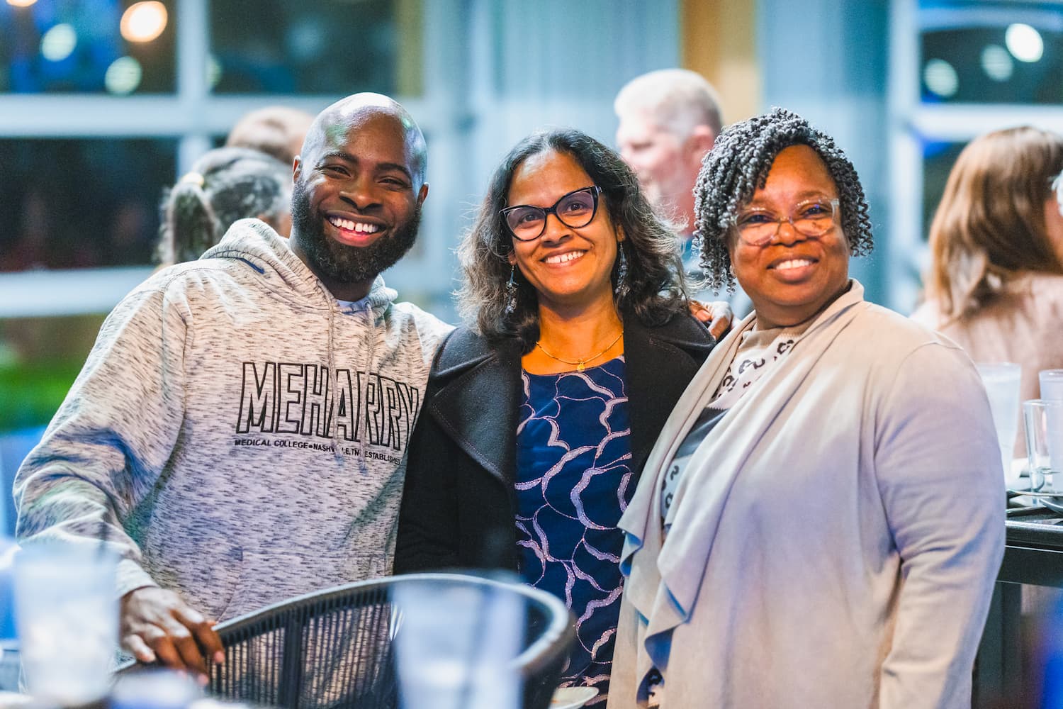 Dr. Justin Turner, Dr. Manju George and Jimmie Wells smile at the CCRI holiday gathering at TopGolf.