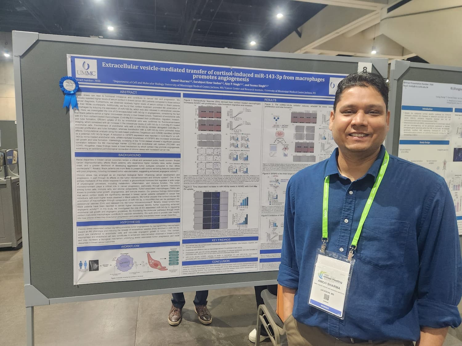 Dr. Amod Sharma smiles beside his research poster at the AACR Annual Meeting.