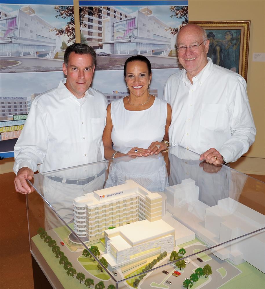 The Friends of Children's Hospital announced fund‐raising efforts to build a pediatric heart center  at its annual Enchanted Evening event. Standing in front of a model of the center are, from left, Dr. Rick  Barr, chairman of the UMMC Department of Pediatrics, Sara Ray, chairman of the Friends board, and Dr.  James Keeton, UMMC vice chancellor for health affairs.