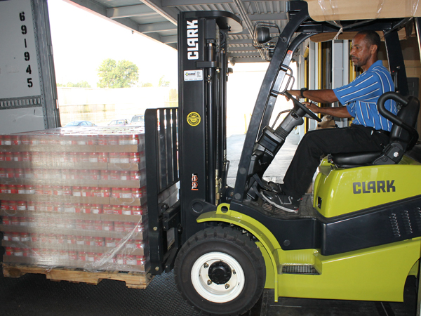Mike Roche, warehouse manager at the Mississippi Food Network in Jackson, uses a forklift to transport peanut butter to waiting trucks for distribution.