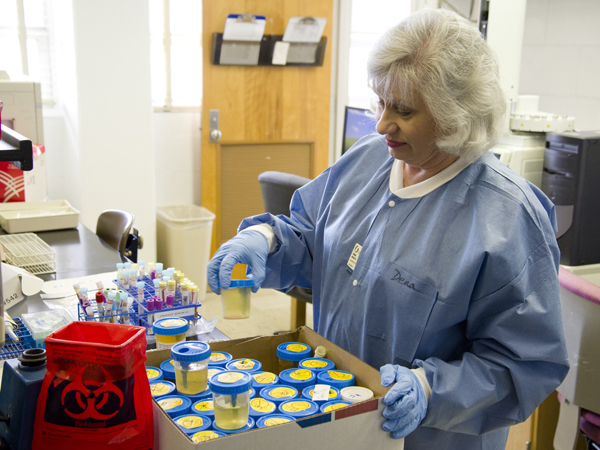 Dena Booth, a registered medical technologist at the University of Mississippi Medical Center, sorts through urine samples collected from patients admitted to various Mississippi hospitals for spice-related overdose symptoms.
