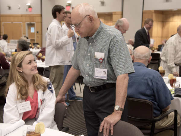 Hannah Green, left, a medical student volunteer, visits with Dr. Frazier Ward, Class of '65.