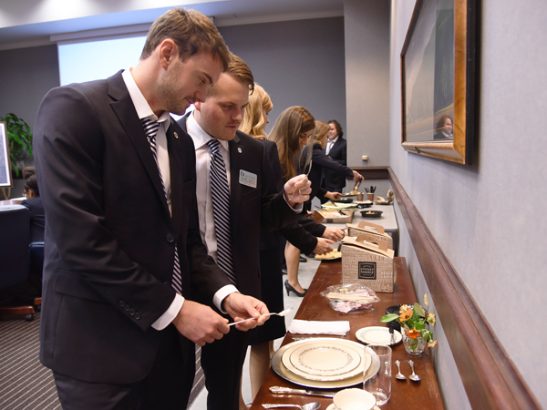 Miles Backstrom, left, and Brooks Jackson go over the proper placement of plates and silverware during their meeting November 10 at the Norman C. Nelson Student Union.