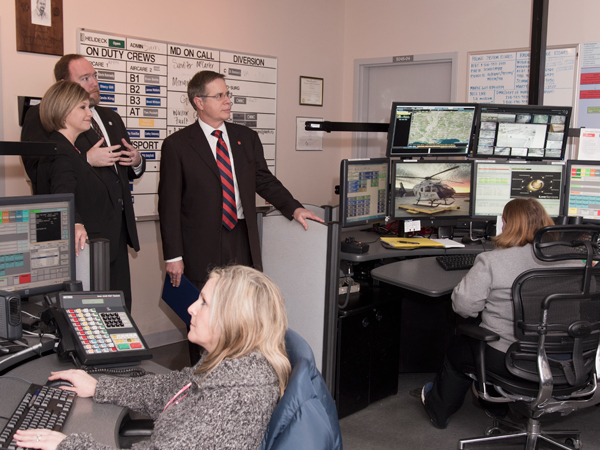 Woodward (upper left) and Wilson chat with Vitter (center), during a visit to Mississippi MED-COM. The communications hub's staff includes EMT basic Tammy Holliman (seated left) and communications specialist Samantha Tucker.