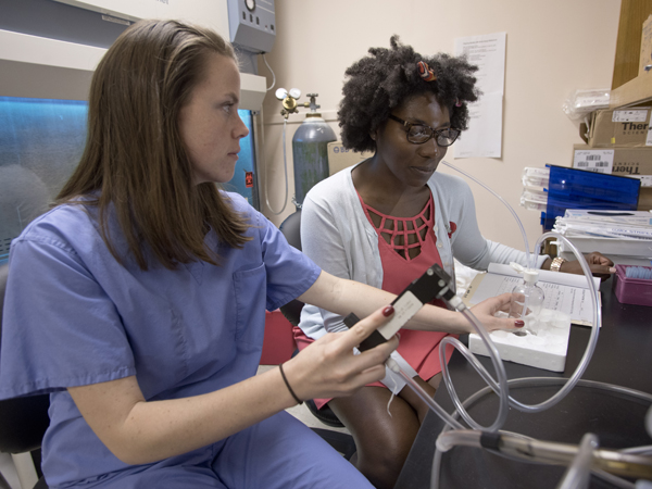 Second-year School of Medicine student Jillian Merica (left) prepares fellow M2 Britney Williams to take a test in which Williams breathes in a specific odor to gauge if it makes her asthma better or worse.