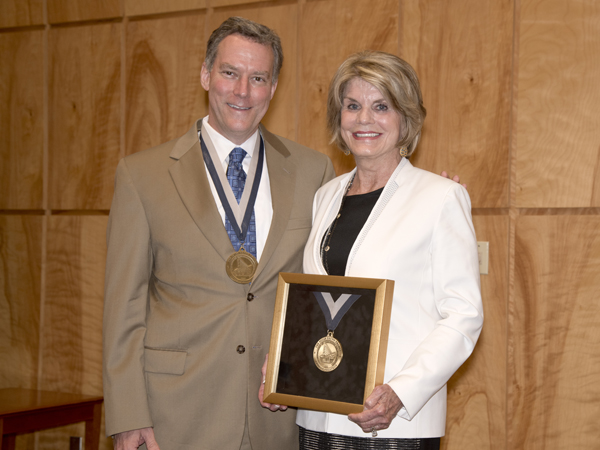 Dr. Rick Barr, left, the current chair of the Department of Pediatrics, and Suzan Thames, the namesake of the endowed chair, display their medals.