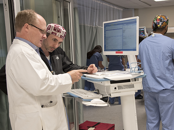 Dr. Jay Shake (left), associate professor of cardiothoracic surgery, and Dr. Sloan Youngblood, assistant professor of anesthesiology, review a patient’s electronic medical record.