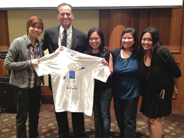 Giroux and a group of teachers in Singapore display a t-shirt that features the curriculum's mascot, Mat Man.