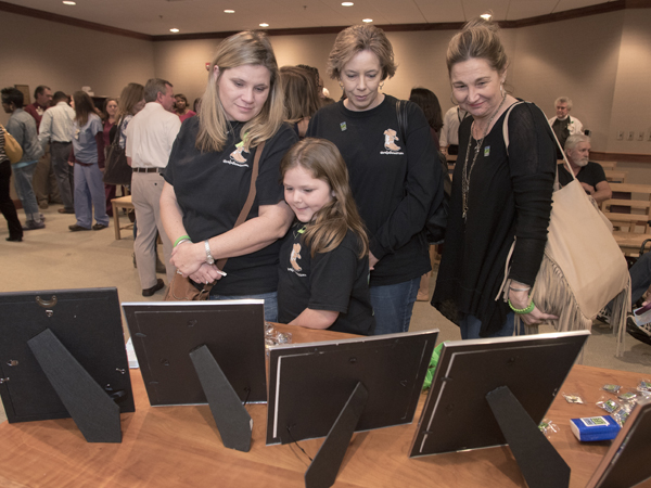 The family of organ donor Carmen Smith, including Maggie Burns, center, and, from left, Jennifer Burns, Lisa Smith and Christy Wells, view photos of those whose lives have been saved by organ donation.