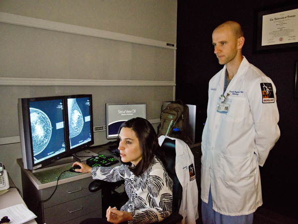 As Tim gives input, Katie examines a patient's mammogram scans at UMMC Grenada's Imaging Center.