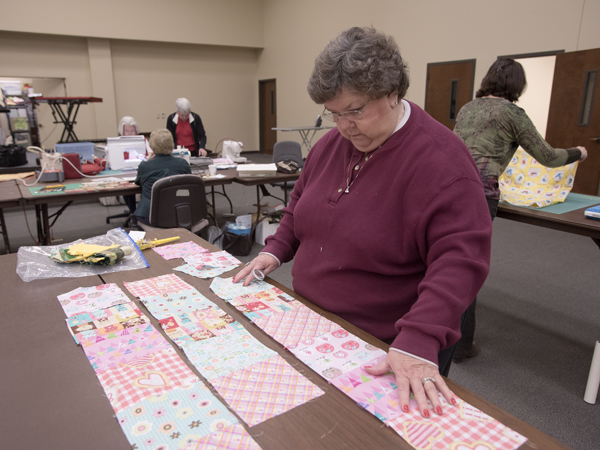 Roanoke McDonald puts quilt squares in place during a meeting of the Susannah Stitchers.