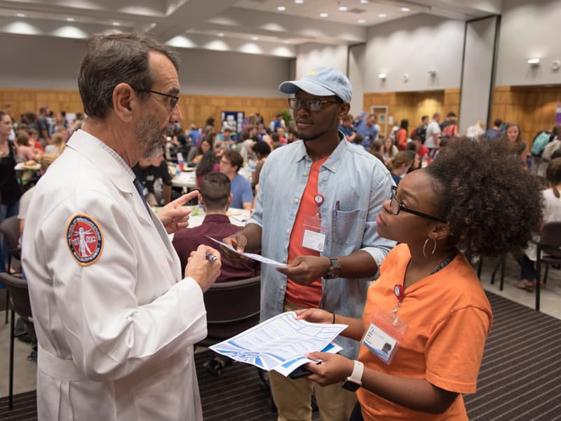 Dr. Rob Rockhold, left, talks with first-year medical students Lorenzo Spencer and Anissa Butler.