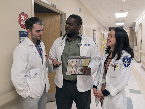 During his internal medicine rotation, Omonuwa Adah, center, sounds out fellow medical students Eric Wilkerson and Adria Luk.