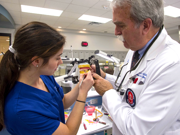 Felton assists third-year dental student Christina McRea with creating a set of dentures.