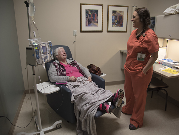 Cancer Institute registered nurse Heather Zamora cares for Hinton during her final chemo infusion.