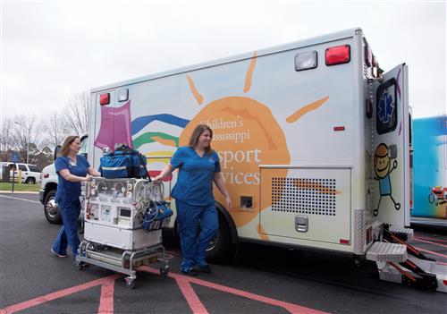 Nurses Kathy Hamilton and Lauren Russell, members of the neonatal transport care team at UMMC, move an incubator to the new neonatal ambulance.