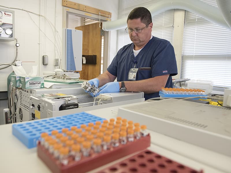 Lee Spencer, lead technologist in the Medical Center's toxicology laboratory, uses sophisticated equipment to analyze samples of opioid and synthetic opioid drugs.
