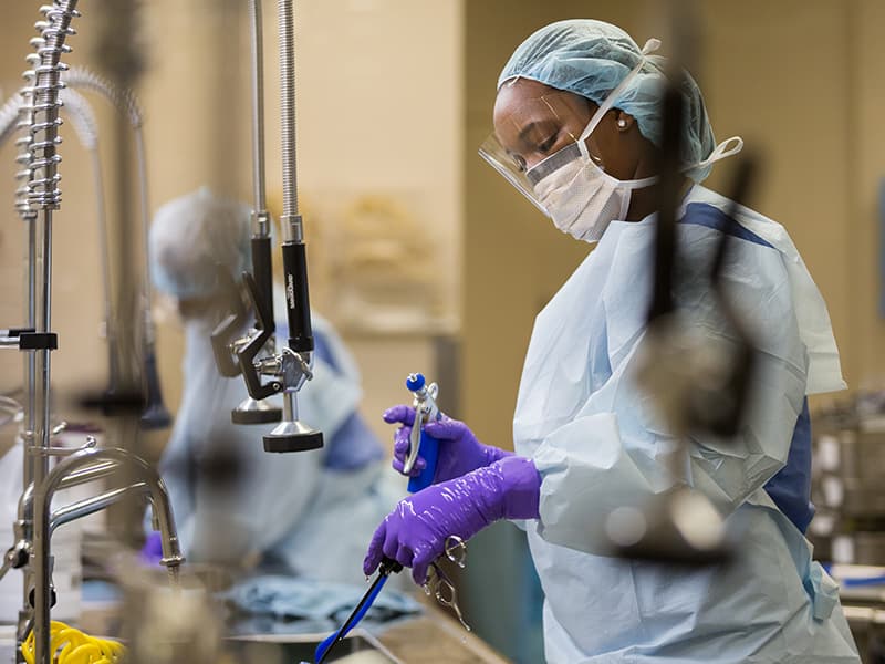 Naporcsha VanBuren, foreground, and Kimberly Thompson, sterile processing technicians, clean medical instruments in UMMC's Sterilization Processing Center.