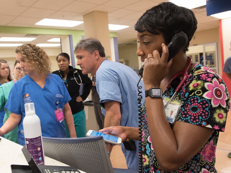 Alicia Thompson, right, a respiratory therapist in the Pediatric ED, takes a call during the Wheels of the Bus disaster drill.