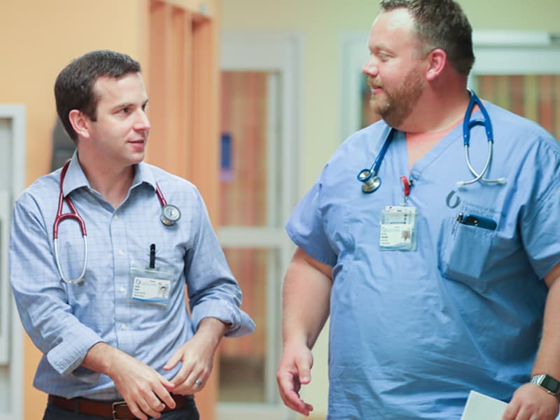 Dr. Justin Davis, center, confers with resident Dr. Eric McDonald in the Pediatric Emergency Department. Davis, assistant professor of pediatric emergency medicine, is co-investigator of a research project exploring child hunger.