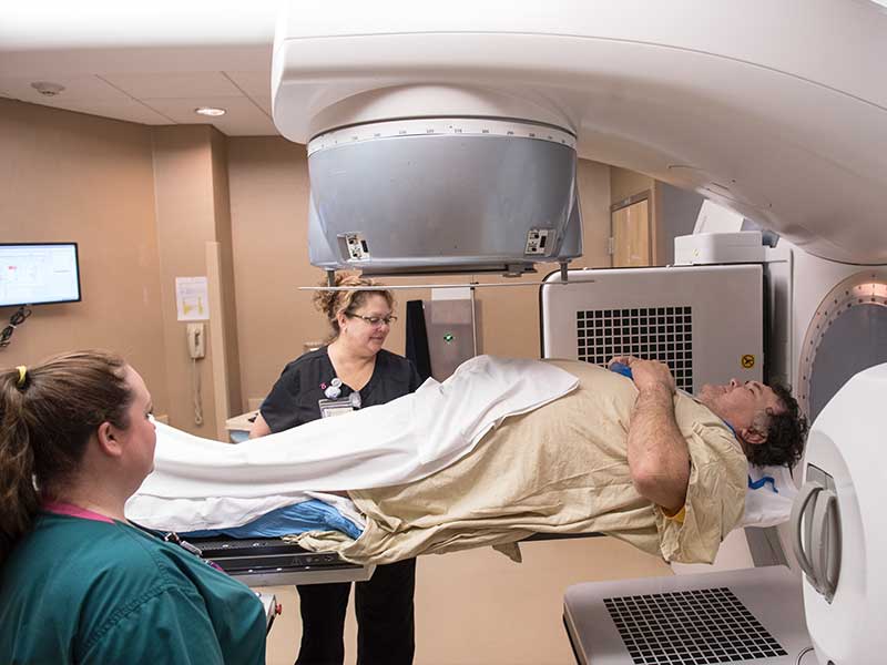 With assistance from radiation technologist Jessica Walters, left, and Kelly Salmons, Billy Jinks of Brookhaven receives radiation treatment for prostate cancer at the Medical Center's radiology oncology department.