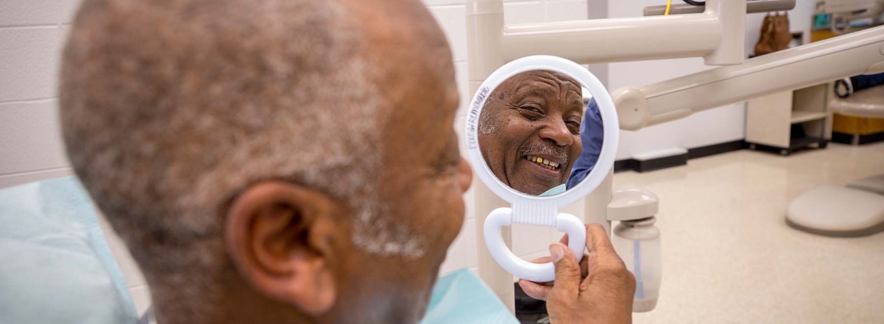 veteran smiles into handheld mirror