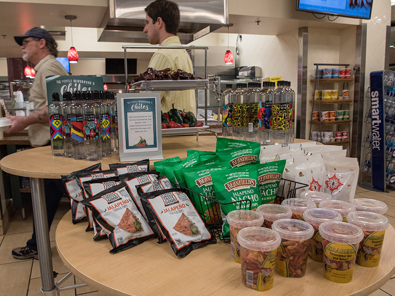 The chili pepper "superfood" display includes gluten-free, vegan jalapeno rice and bean chips, baked jalapeno tortilla chips, and a hot and spicy snack mix.