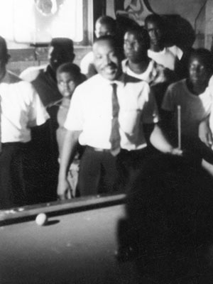 The Rev. Martin Luther King Jr. is surrounded by admirers in a Neshoba County pool hall, where he spoke about registering to vote and supporting the Mississippi Freedom Democratic Party, July 1964. (Photo used with the permission of the Rev. Ed King, University Press of Mississippi and the Mississippi Department of Archives and History)