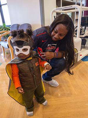 Ole Miss softball player Elantra Cox and Children's of Mississippi patient Nasi Rai Strickland play superhero during Cox's visit to Batson Children's Hospital.