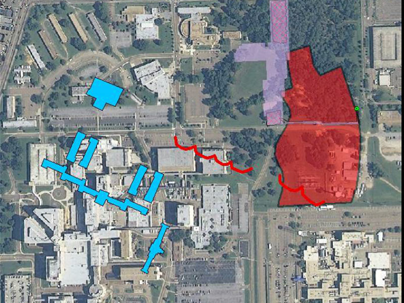 A modern-day aerial view of the Medical Center campus is enhanced with a historic overlay of the asylum's main buildings (in blue) and the cemetery boundary (in red).